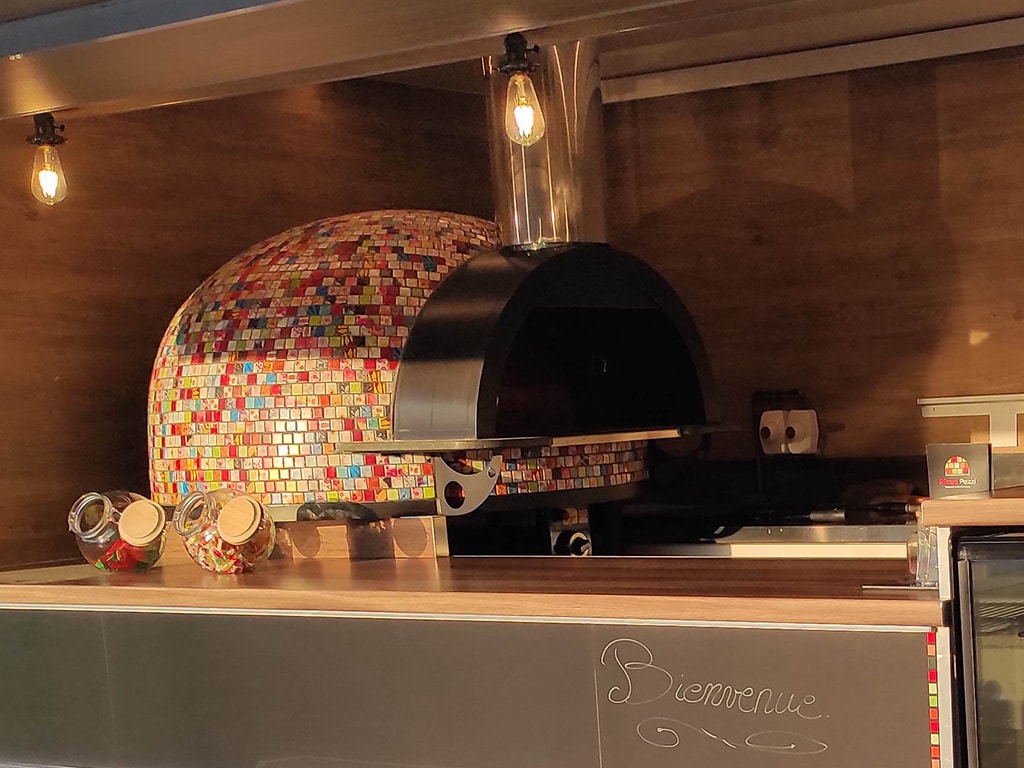 Four napolitain recouvert d'une mosaïque multicolore dans le camion Pizza Pezzi